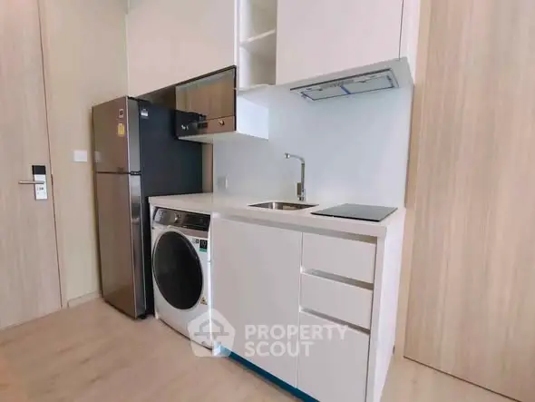 Modern compact kitchen with integrated appliances and sleek design.