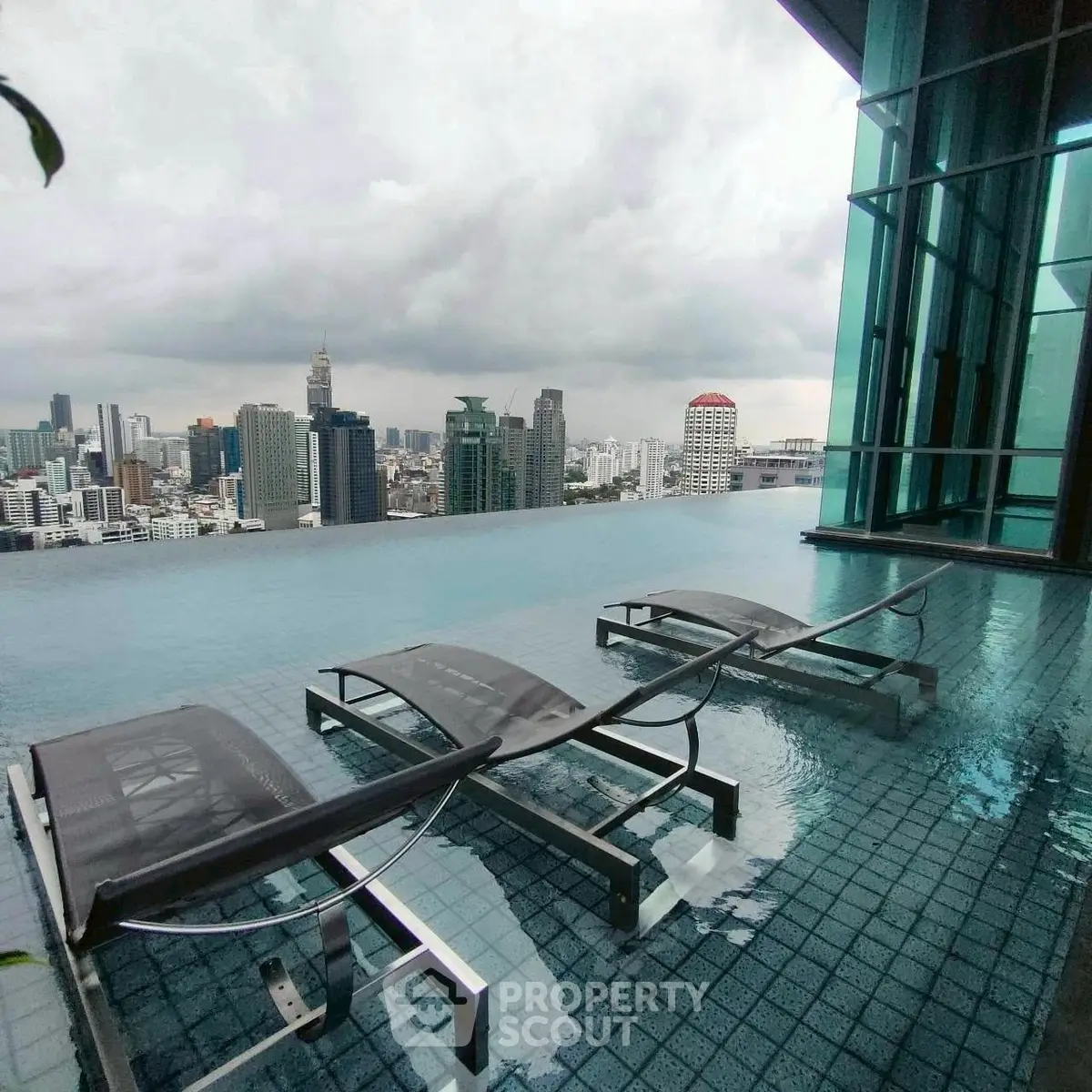 Luxurious rooftop infinity pool with stunning city skyline view, perfect for relaxation and leisure.