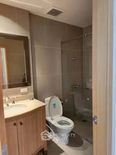 Modern bathroom with glass shower and elegant fixtures in a contemporary home.