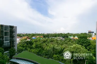 Stunning panoramic view from high-rise building overlooking lush greenery and cityscape.