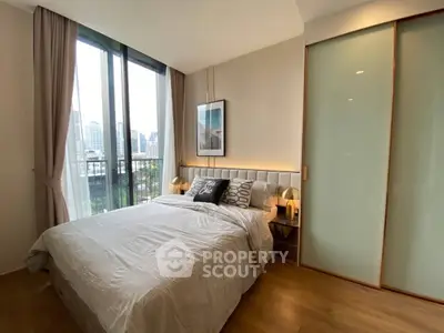 Modern bedroom with city view, featuring large windows and stylish decor.