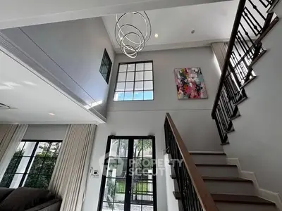 Elegant modern living room with high ceiling and stylish staircase