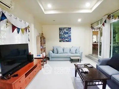 Spacious living room with modern decor and large TV setup