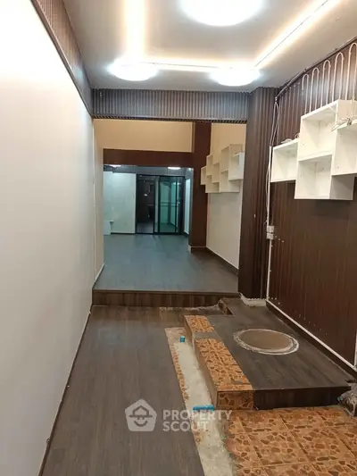 Spacious interior with modern wooden flooring and unique shelving, ideal for creative design opportunities.