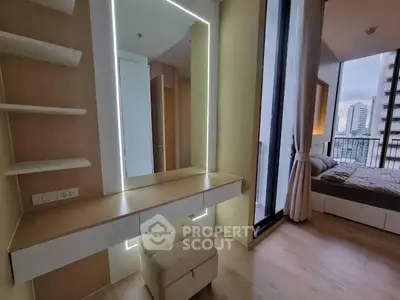 Modern bedroom with floor-to-ceiling windows and city view, featuring a stylish vanity and cozy decor.