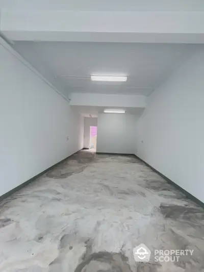 Spacious empty room with unique flooring and bright lighting, ideal for customization.