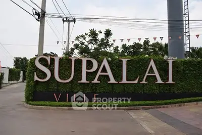 Entrance sign of Supalai Ville with lush greenery and modern design.
