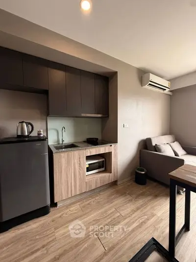 Modern compact kitchen with sleek cabinetry and cozy living area