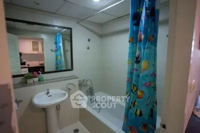 Cozy bathroom with bathtub and vibrant fish-themed shower curtain