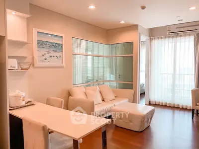 Modern living room with elegant decor and natural light, featuring a cozy seating area and stylish furnishings.