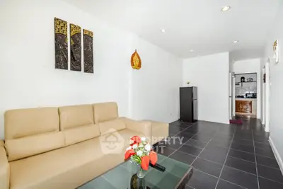 Modern living room with beige sofa and sleek black tile flooring