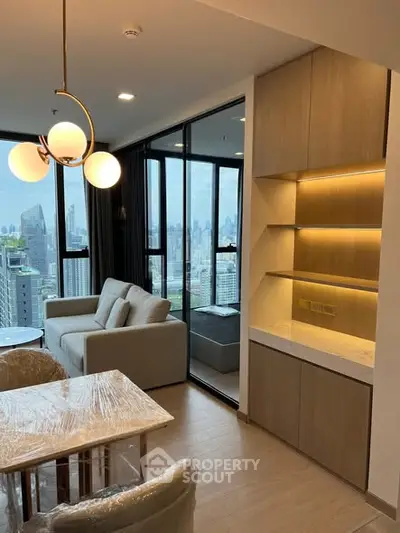 Modern living room with city view, featuring elegant lighting and stylish furniture in a high-rise apartment.