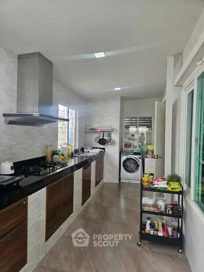 Modern kitchen with sleek cabinets and integrated washing machine, perfect for urban living.