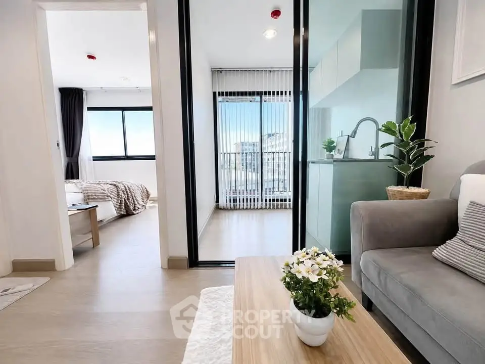 Modern apartment interior with cozy living room and stylish kitchen, featuring a bright bedroom view.
