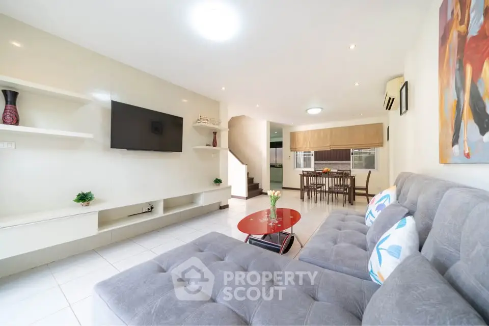 Spacious modern living room with stylish decor and open dining area, perfect for entertaining.
