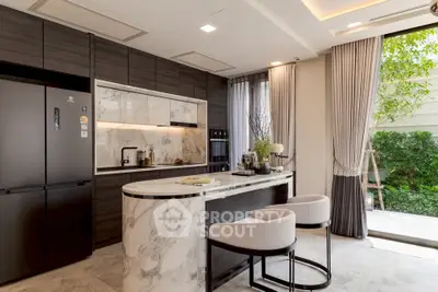 Luxurious modern kitchen with marble island and sleek appliances, opening to a lush garden view.
