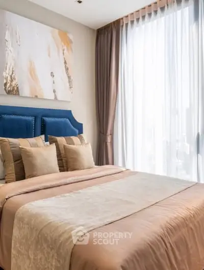 Luxurious bedroom with elegant decor and large window offering natural light.