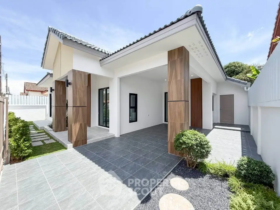 Modern single-story house with spacious driveway and landscaped garden