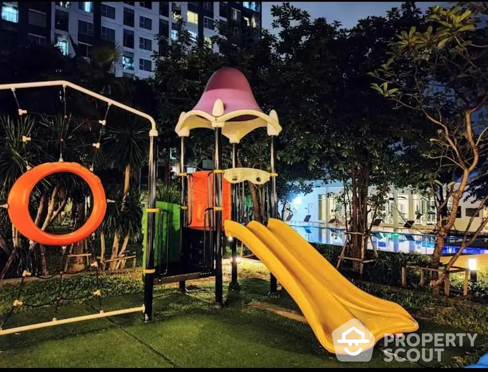 Modern apartment complex with vibrant playground at night, ideal for families seeking urban living.