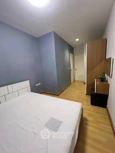 Cozy bedroom with modern decor and wooden flooring, perfect for relaxation and comfort.
