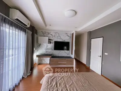 Spacious modern bedroom with large window and stylish decor