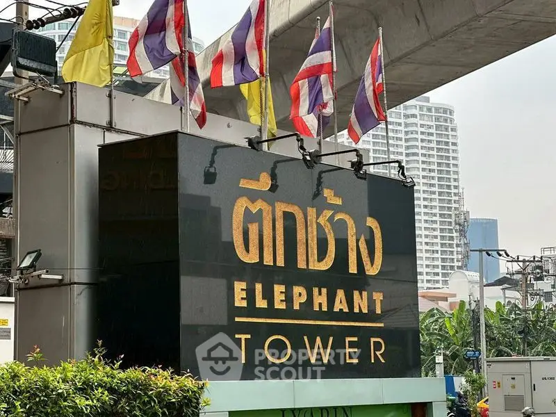 Iconic Elephant Tower sign with cityscape background, showcasing urban architecture.