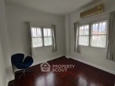 Spacious room with elegant wooden flooring and large windows, perfect for a cozy living space.