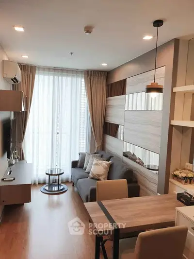 Modern living room with stylish decor and natural light, featuring a cozy sofa and elegant furnishings.