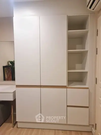 Modern white storage cabinet with open shelves in a stylish interior space.