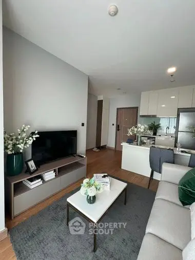 Elegant open-plan living space with modern furnishings, seamlessly connecting to a sleek kitchen, perfect for entertaining and relaxation.