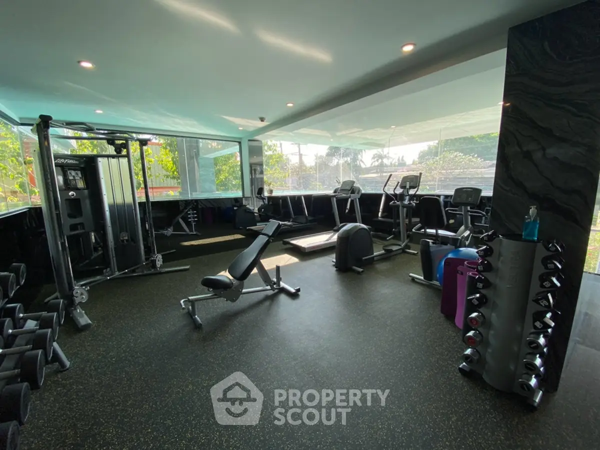 Modern gym with state-of-the-art equipment and large windows offering a scenic view.
