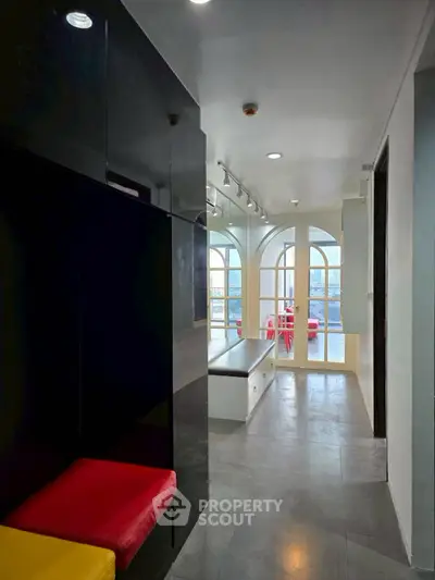 Modern interior with colorful seating and large windows offering city views