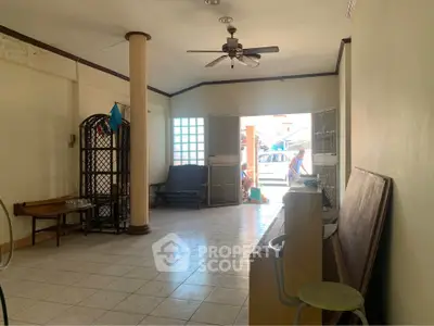 Spacious interior with tiled flooring and ceiling fan, ideal for versatile use.
