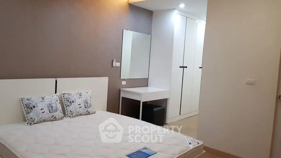 Modern bedroom with stylish decor and ample storage space in a cozy apartment.