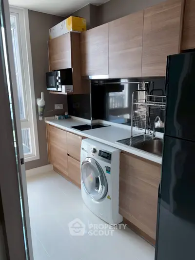 Modern kitchen with sleek wooden cabinets and built-in washing machine