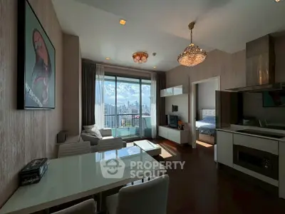 Modern living room with city view, elegant chandelier, and open kitchen layout in a high-rise apartment.