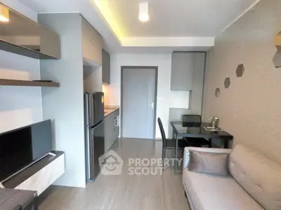Modern living room with sleek furniture and open kitchen layout in a stylish apartment.
