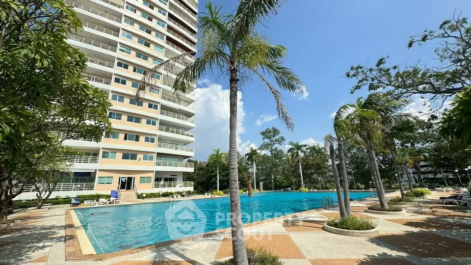 Luxurious condominium with stunning pool and palm trees, perfect for resort-style living.