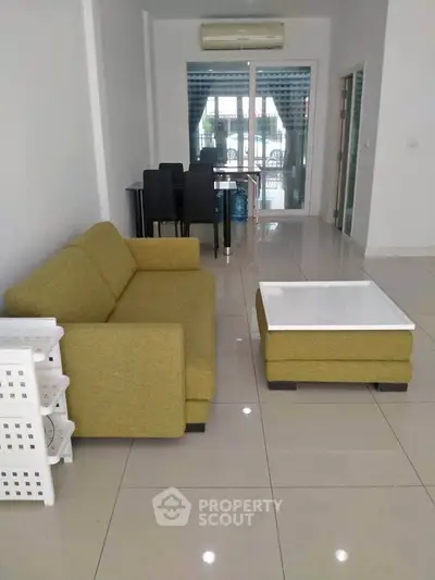 Spacious living room with modern furniture and dining area in open layout.