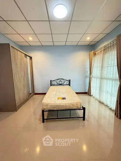 Spacious bedroom with natural light and modern furnishings