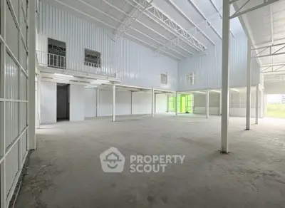 Spacious industrial warehouse with high ceilings and ample natural light.