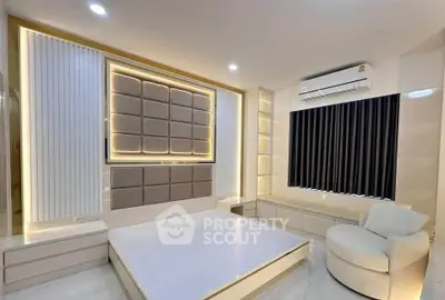 Modern bedroom with stylish lighting and air conditioning, featuring a unique padded wall design.
