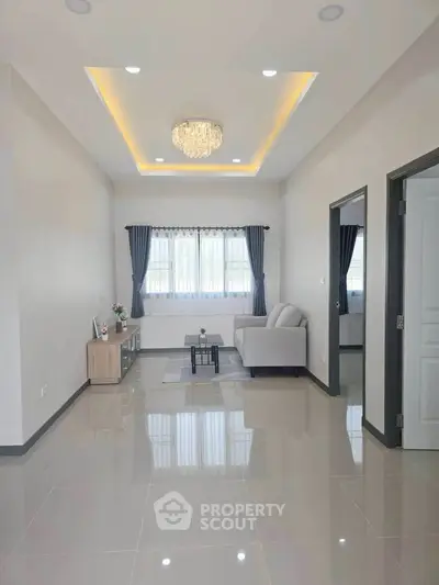 Elegant living room with modern chandelier and sleek tile flooring, perfect for stylish urban living.