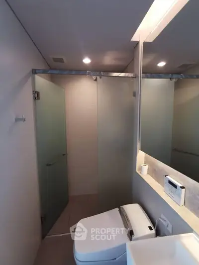 Modern bathroom with frosted glass shower and sleek fixtures