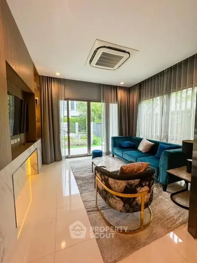 Luxurious living room with modern decor and large windows offering garden view.