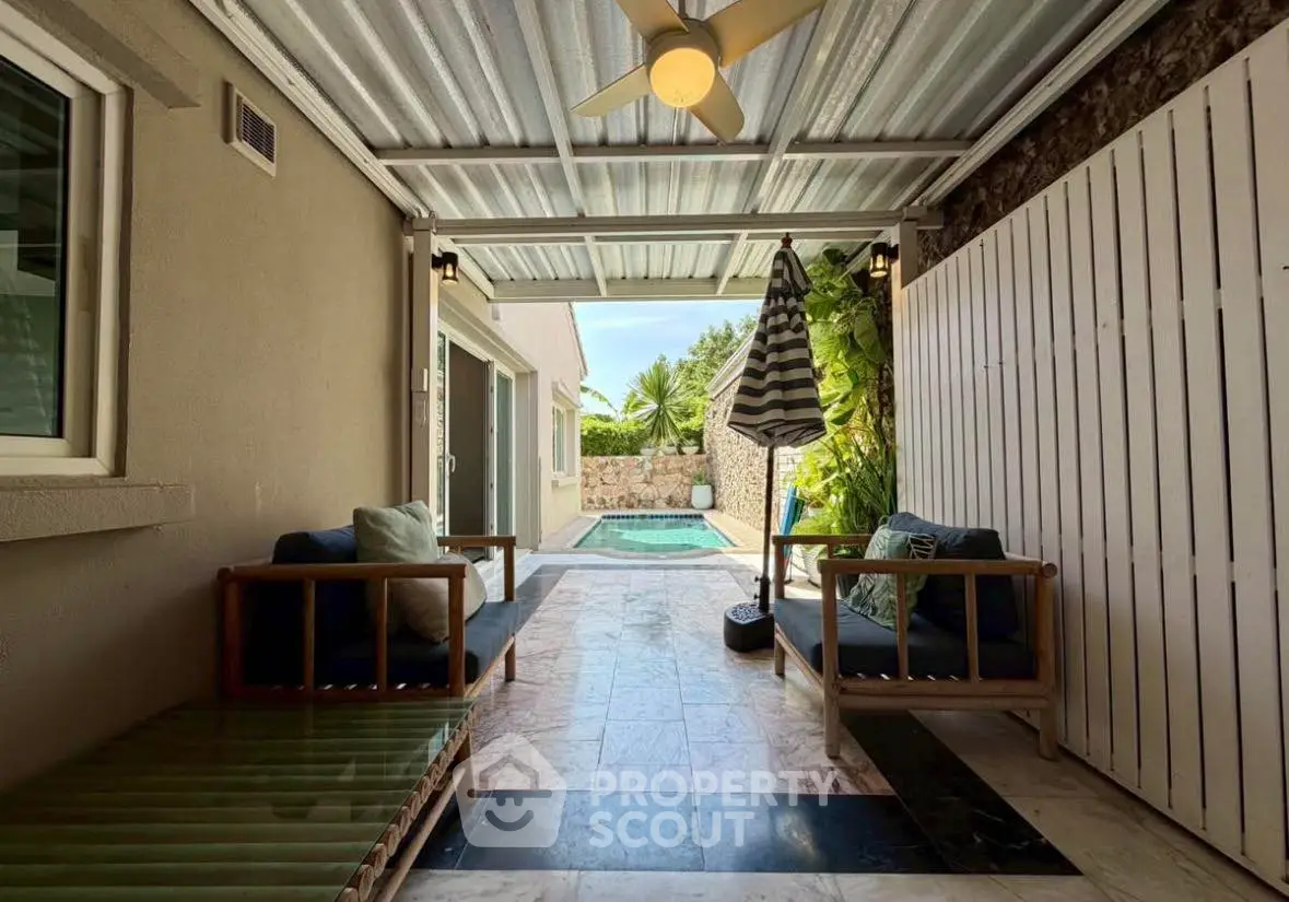 Charming covered patio with cozy seating and pool view, perfect for relaxation and outdoor enjoyment.