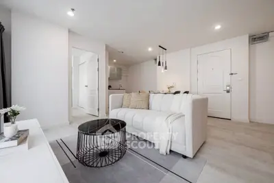 Modern living room with elegant decor and open kitchen layout in a stylish apartment.