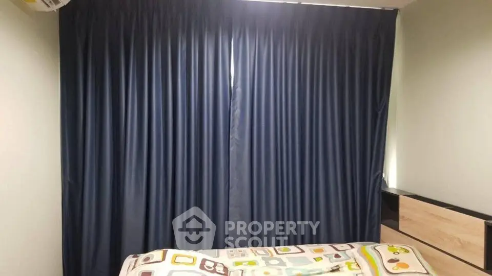 Cozy bedroom with dark curtains and colorful bedding, perfect for restful nights.