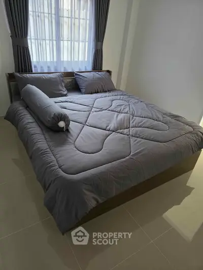 Cozy bedroom with stylish gray bedding and natural light