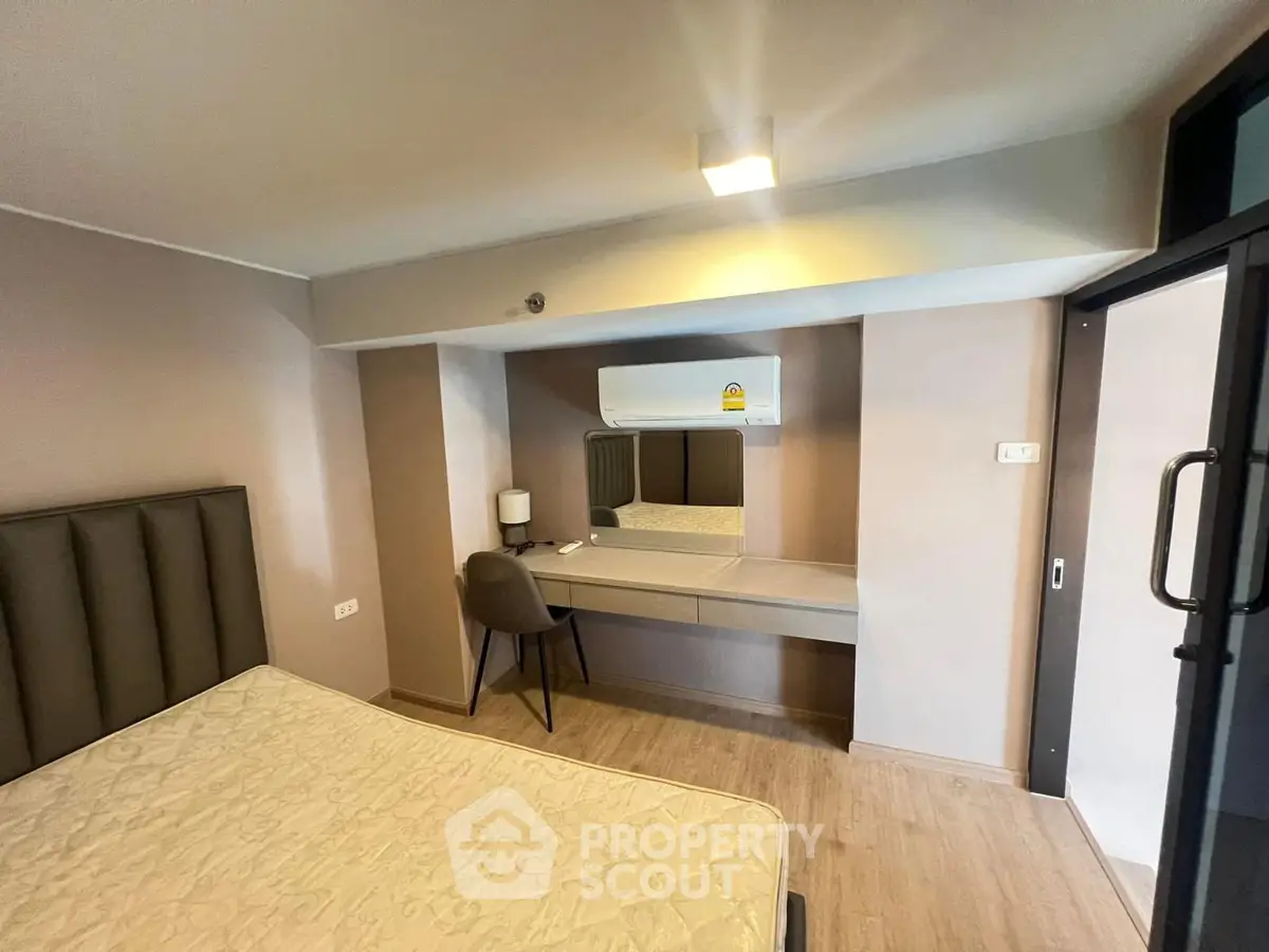 Modern bedroom with stylish decor and built-in desk, perfect for comfortable living.